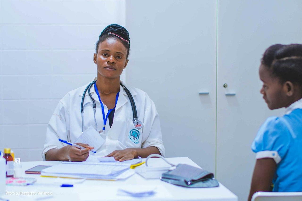 A health worker talking with a young girl in a clinic