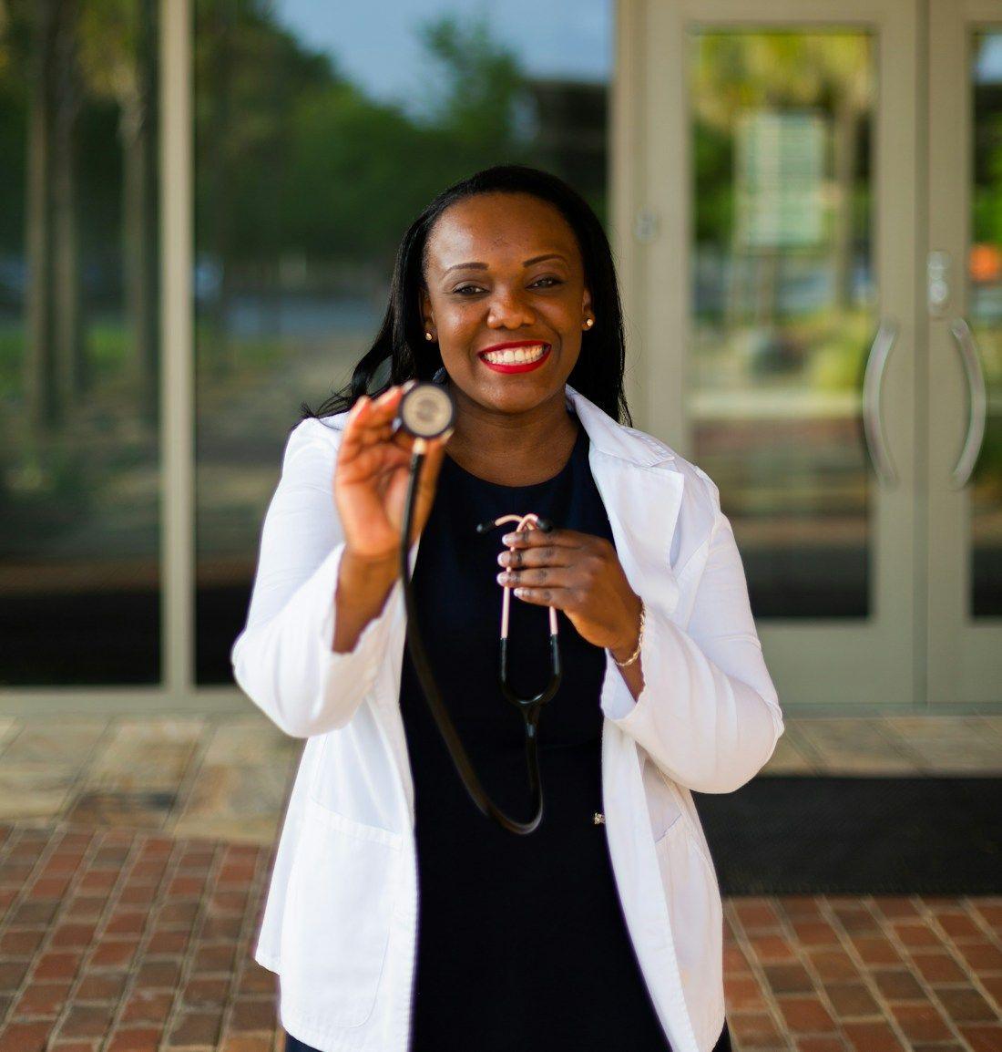 A smiling health worker holding a stethoscope