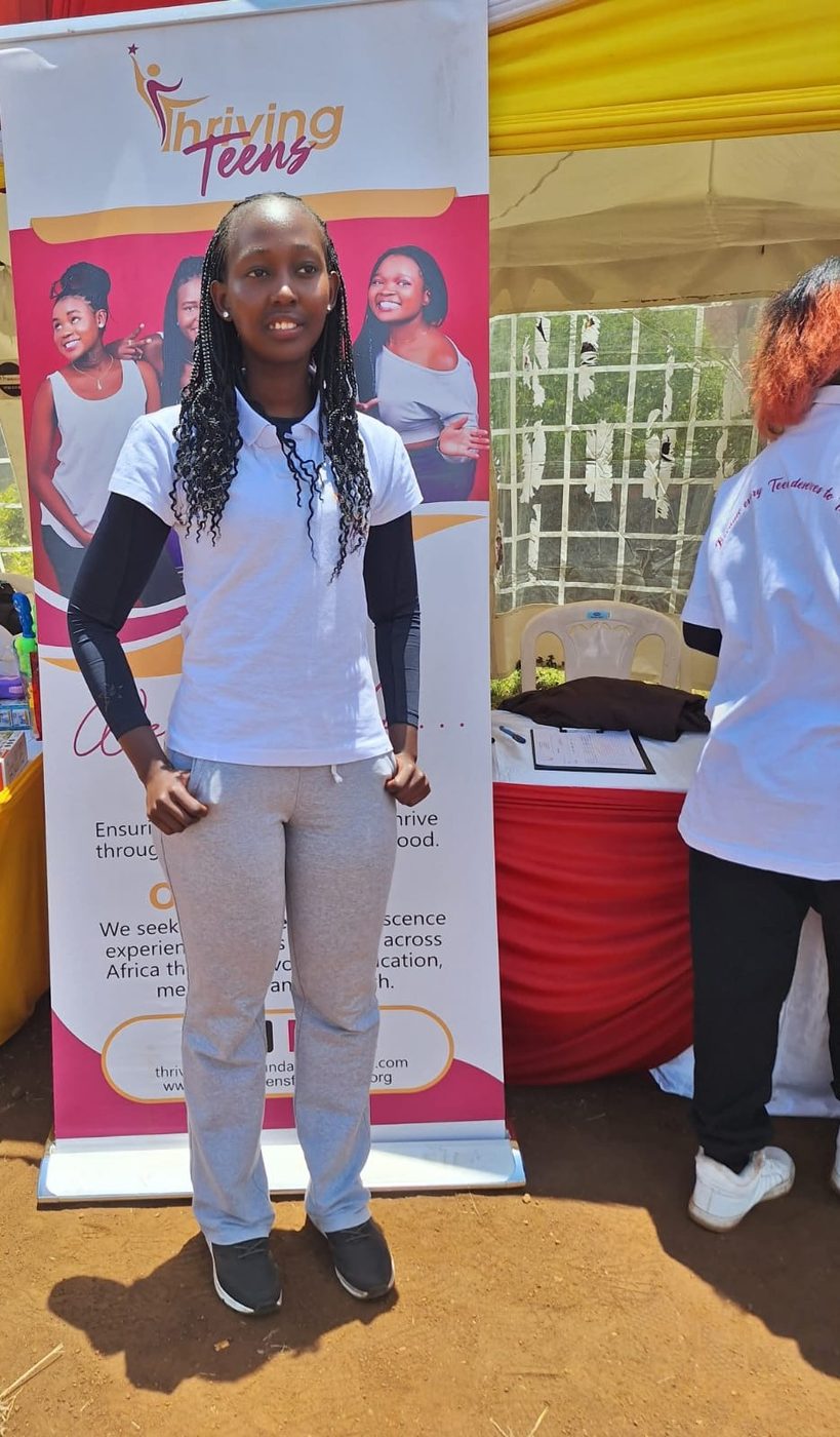 A Thriving Teens volunteer standing at the outreach banner